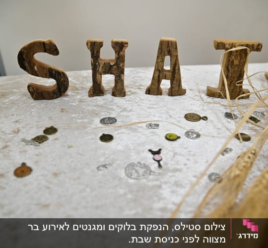 אותיות עץ על שולחן עם מטבעות וקישוטים